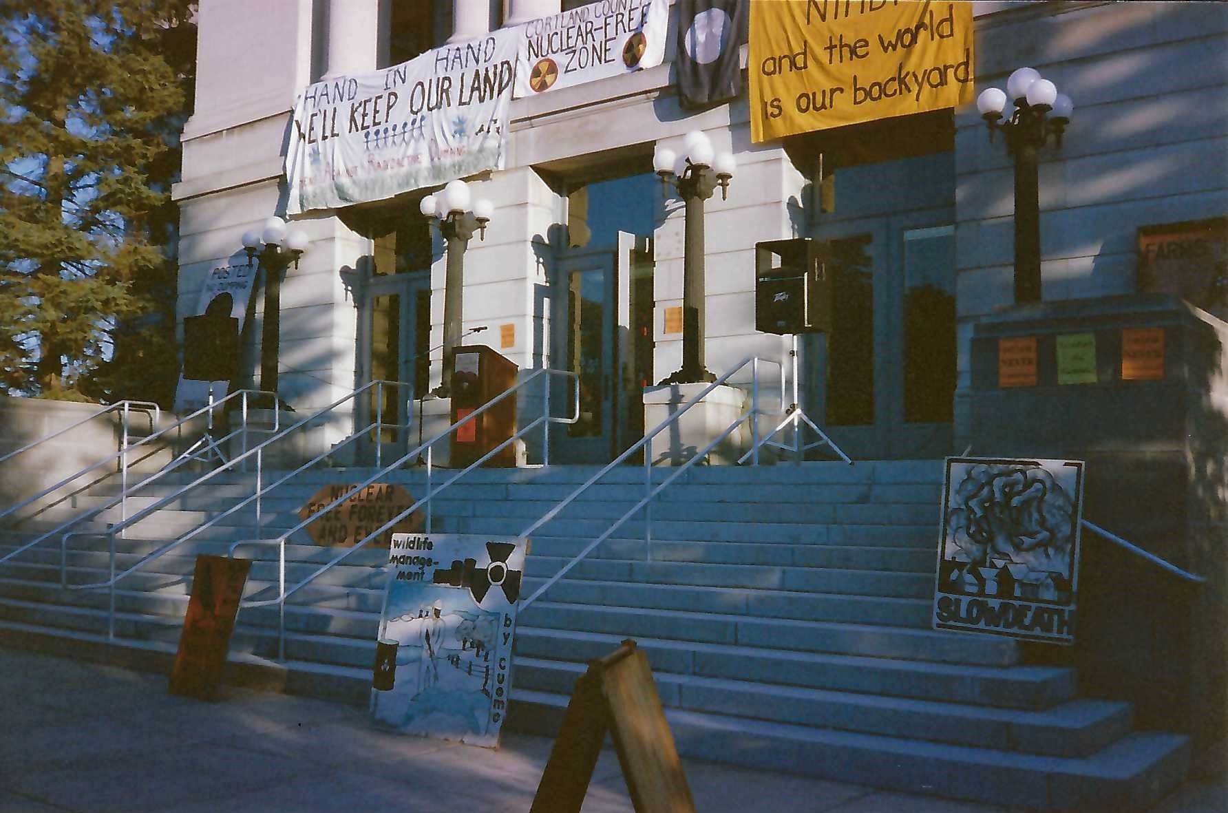 Cortland County Courthouse steps with signs and posters featuring anti-radioactive waste dump slogans
